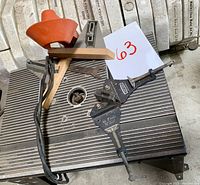 Craftsman router table with ribbed metal top, orange plastic safety guard, wooden clamps attached, power cord visible.