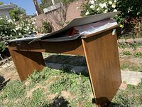 Wooden drafting table outdoors with drafting supplies on top