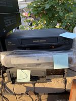 Top view showing Philips VHS VCR on top of other stereo equipment including Magnavox device and Yamaha amplifier with wood panel sides