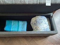Photo of wool blanket and quilt folded inside a storage bench.