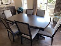 Wide view of six matching chairs arranged around a dining table showing overall set and condition