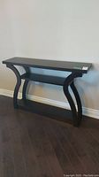 Front view of dark wood console table showing curved legs and shelf