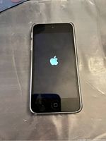 Front view of Apple iPod Touch powered on with Apple logo visible on screen