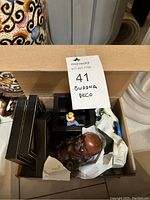 Photo of boxed Buddha decor items with paper wrapping inside box