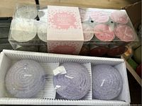 Photo of 22-pack scented tea light candles in a clear plastic container with white and pink candles visible