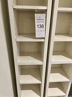 Close-up view of one white shelving unit showing compartments and label for lot with lot number.