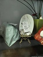 Photo of oval decorative plate wrapped in protective packing material with a label indicating 'Decorative Plate'.