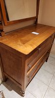 Side angled view of oak dresser showing top surface and attached mirror frame.