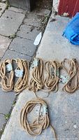 Six coiled decorative natural fiber ropes on concrete surface.