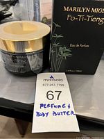 Photo showing the body butter jar with gold lid alongside the perfume box labeled Marilyn Miglin Fo-Ti-Tieng Eau de Parfum 3.4 fl oz/100 ml.
