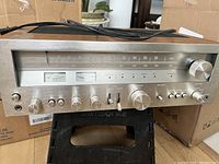 Front view of vintage radio receiver showing AM/FM dial, tuning and volume knobs, and meters.