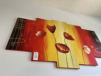 View of 7-piece floral wall art arranged on a white wall showing the panel layout and design.