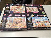Four Wasgij? brand boxed 1000-piece jigsaw puzzles with illustrated cartoon scenes visible on the front of the boxes.