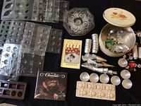 Two images of a collection of baking tools and cookbooks arranged on a dark surface, showing chocolate molds, tart shells, cream horn molds, cookie cutters, canisters, cookbooks, glass tiered cake plates, and decorative cookie tin.