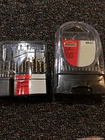 Two unopened Jobmate bit sets in plastic cases showing the front labels and contents.