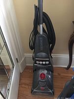 Full view of upright Bissell StainPro carpet cleaner showing overall height, body, hose and cord wrap