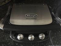 Top view of DeLonghi MultiGrill closed with brand and model logo visible.