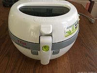 Front view of T-fal ActiFry Original air fryer showing brand label and locking handle