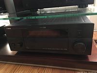 Front view of Yamaha RX-V3800 receiver showing black finish, power knob, input selector, and display screen