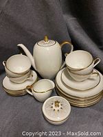Full set arranged showing tea pot, cups, saucers, plates, creamer and sugar bowl with lid.