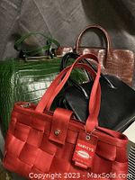 Four different purses displayed together, showing variety of colors and styles