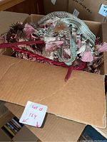 Box with coiled pieces of tapestry featuring tassels in various colors and materials
