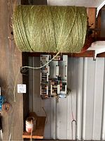 Two large bulls of green twine with a smaller roll of twine placed below, displaying the scale and thickness of twine.