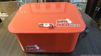Closed view of the orange Big Red parts washer showing the lid with handle and branding decals.