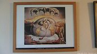 Framed Salvador Dali print titled "Geopoliticus: Child Watching the Birth of the New Man." Image shows surrealistic cracked egg figure with earthy color palette in maple frame.