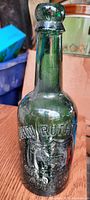 Front view showing embossed company name 'John Rothwell Bolton' and detailed animal graphics on the bottle body