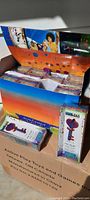 Full case box opened showing multiple unopened toy packages neatly arranged inside, colorful product and display graphics visible.