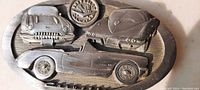 Close-up of the heavy cast steel belt buckle showing detailed Corvette graphics and emblem at the center