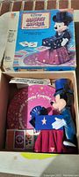 Photo of vintage Disney Mickey Mouse Spells-a-Word game toy set showing boxed packaging and included game pieces inside.