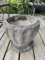 Front angle showing the planter's textured grooves, rough surface, and moss inside.