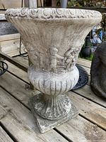 Full view of the concrete planter showing shape, size, and scalloped rim.