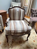 Front view of the upholstered bergère chair showing fabric and wood details
