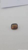Cushion cut deep whiskey-colored Madeira citrine viewed from angle, showing color and cut facets.