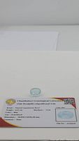 Aquamarine gemstone placed on top of GLC certification card showing size 13.83x10.90 mm and other details.