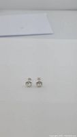 Front on photo of the pair of round clear quartz stud earrings with sterling silver bezel settings.