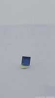 Square-cut sapphire displayed flat on white background