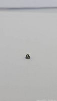 Single natural mint green heart-shaped sapphire gemstone viewed against light background. Shows the stone's heart shape and color.
