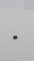 Loose cushion-cut blue spinel on white background, distance view