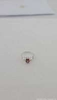 Front view of sterling silver ring with deep red pear-shaped garnet gemstone, size 6.