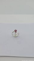 Silver ring with a pear-shaped red garnet gemstone photographed on a white background.