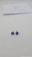 Pair of blue sapphire stud earrings shown front view on white background