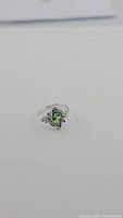 Front angle view of the sterling silver Peridot ring showing the green pear-shaped stone and silver swirled detail.