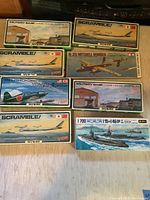 Overview of eight 1/700 scale military model kits including airplanes, bombers, military base structures, and submarines.