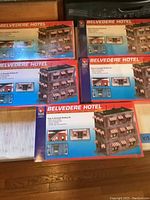 Five sealed boxed Belvedere Hotel HO scale model building kits stacked and arranged showing front and side views, each box displaying the Belvedere Hotel multi-storey hotel model with detailed windows, awnings and lighting features.