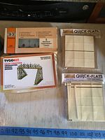 Top view of all kits showing Tyco snap-together crossover signal bridge kit box, Con-Cor electrical transmission towers kit box, and two Quick Flats kits in brown paper packages with visible contents.
