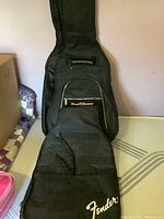 Black Fender soft guitar case laid flat showing Fender logo and front pocket